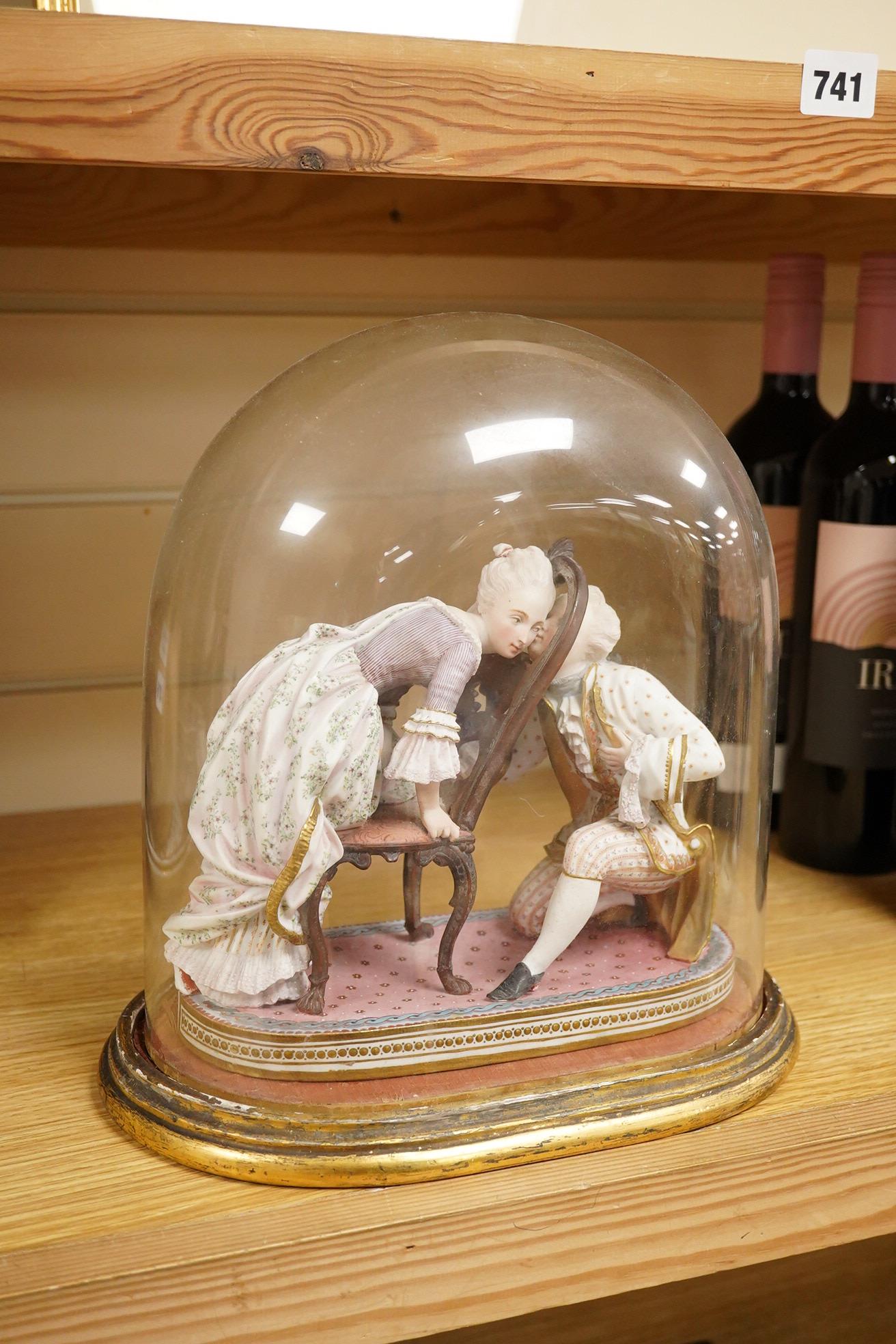 A 19th century biscuit porcelain study of a courting couple under glass dome, raised on gilt base, 28cm high